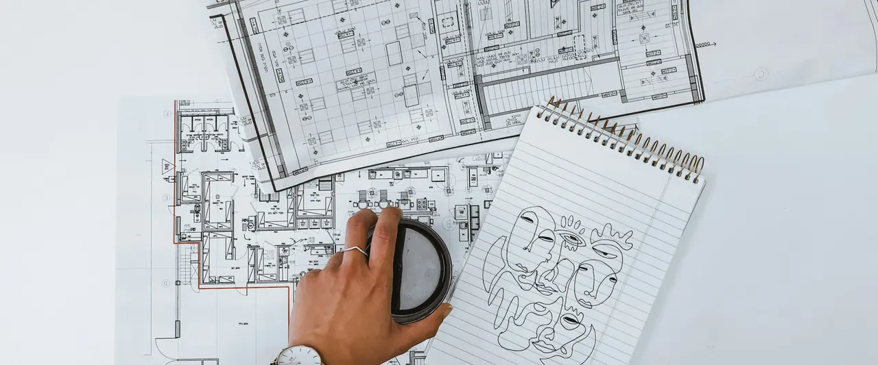 Plans d’architecte et carnet de relevés sur une table